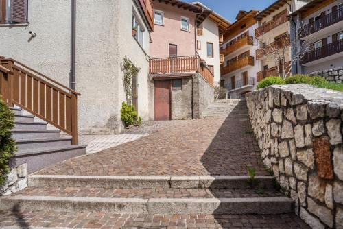 a cobblestone street in a city with buildings at Casa Batistei Ribes in Molveno
