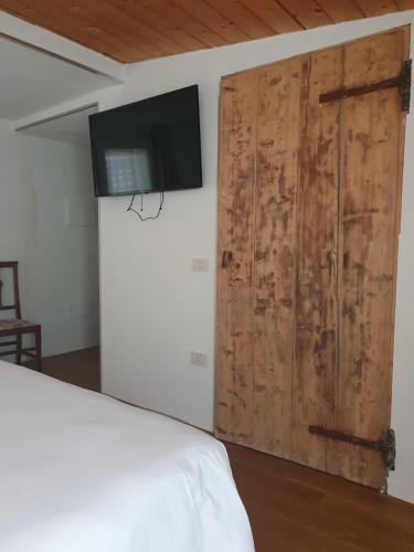 a bedroom with a sliding door and a tv on a wall at Osteria e Locanda Del Viaggiatore in Russi