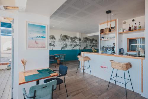 eine Küche mit einer Bar und Stühlen in einem Zimmer in der Unterkunft Hôtel de La Plage in Hossegor