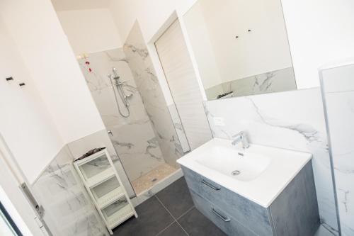 a white bathroom with a sink and a shower at Residence Daniele in Bellaria-Igea Marina