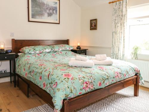 a bedroom with a bed with two towels on it at Periwinkle Cottage in Loughborough