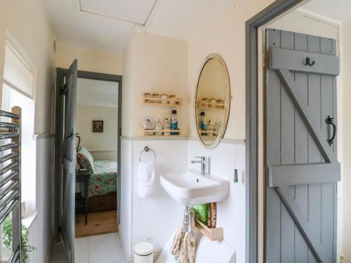 a bathroom with a door leading to a bedroom at Periwinkle Cottage in Loughborough