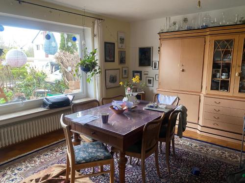 ein Esszimmer mit einem Tisch, Stühlen und einem Fenster in der Unterkunft Nördlingen im Ries - Königsbergerstr. - kleines Gästezimmerchen in Nördlingen