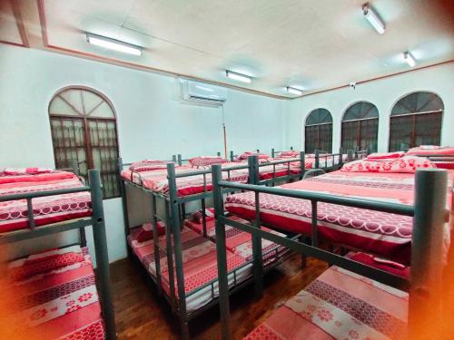 grupa łóżek piętrowych w dużym pokoju w obiekcie Mang Ben Dormitory Kaliraya w mieście Manila