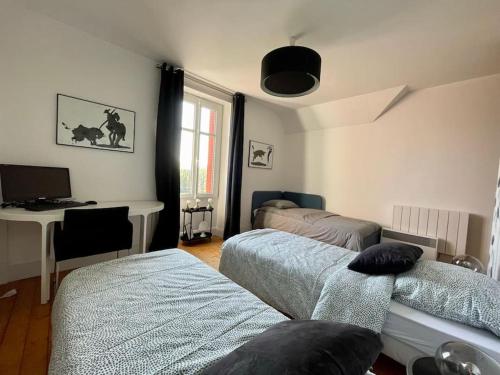 a bedroom with two beds and a desk with a computer at *Belle Epoque* residence between Sologne and Berry in Mennetou-sur-Cher