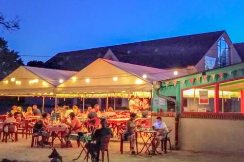 a group of people sitting at tables outside a restaurant at *Belle Epoque* residence between Sologne and Berry in Mennetou-sur-Cher