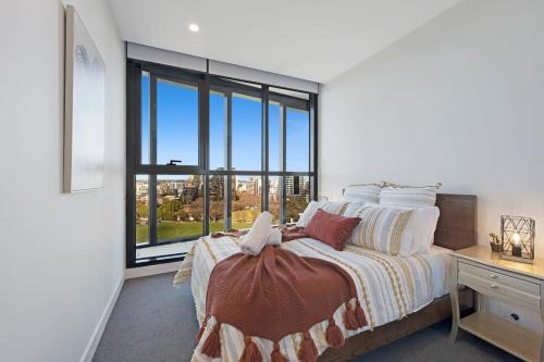 a bedroom with a bed and a large window at Parque on St Kilda - 02532 in Melbourne
