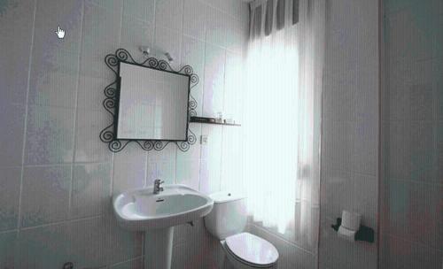 Hotel La Farola del Mar في بو دي يانيس: حمام مع حوض ومرحاض ومرآة