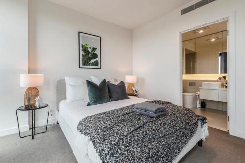 1 dormitorio con 1 cama y baño con lavamanos en Spacious 2 bedroom apartment with Free parking-00189 en Melbourne