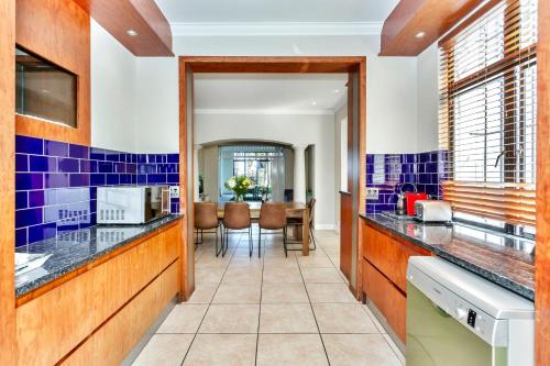 ケープタウンにあるSir David Baird 22の青いタイル張りの壁とダイニングルームのあるキッチン