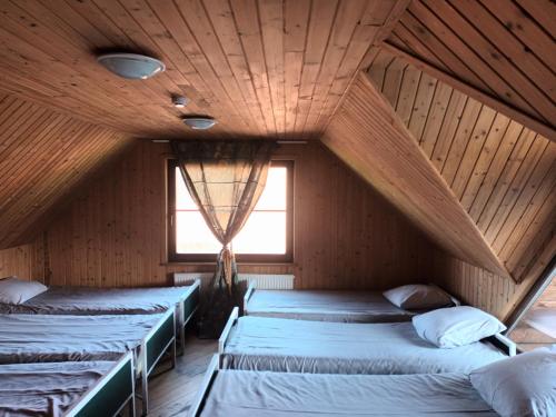 2 camas en una habitación con techo de madera en Prystovų sodyba en Prystovai