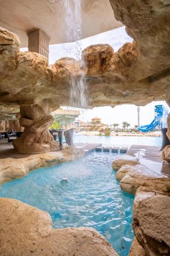 a swimming pool in a cave with a waterfall at Faraana Heights Aqua Park in Sharm El Sheikh