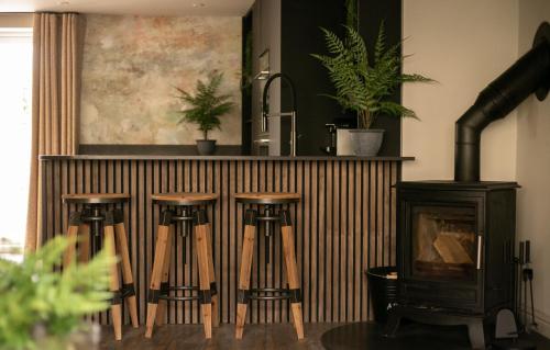 a group of stools next to a stove in a kitchen at Akasha Spa Retreat Cottage in Welton