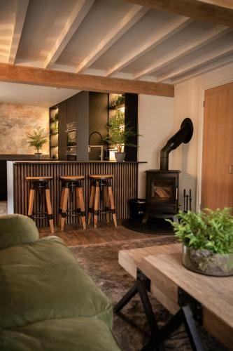 a living room with a couch and a wood stove at Akasha Spa Retreat Cottage in Welton