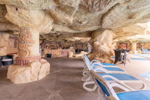 a group of lounge chairs in front of a rock wall at Faraana Heights Aqua Park in Sharm El Sheikh
