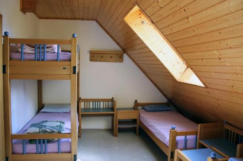 two bunk beds in a room with a attic at PUS Bavšica in Log pod Mangartom