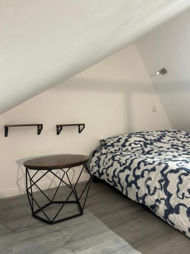 - une chambre avec un lit et une petite table dans l'établissement Grand Place Roubaix Appartement Style Loft, à Roubaix