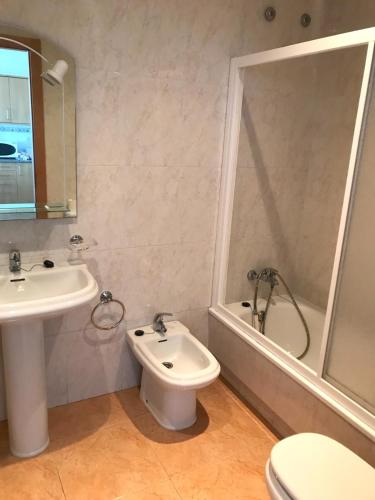 a bathroom with a sink and a toilet and a shower at APARTAMENTOS CANADA 2 in Raxó