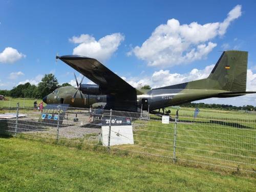 a military plane is on display behind a fence at Ferienwohnung Hohner Seeblick in Hohn