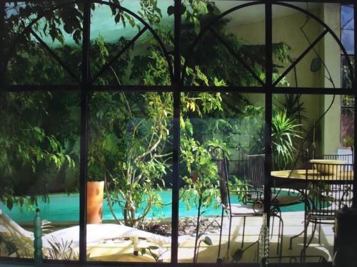 LagnesにあるEcolodge Au fil de l'eau, avec piscine intérieure et parc arboréの窓からプールの景色を望めます。