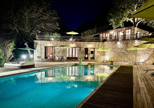 - une piscine en face d'une maison la nuit dans l'établissement Gîte Nature en Luberon, à Céreste
