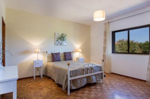 een slaapkamer met een bed en een groot raam bij Casa Silver, Gale - Sleeps 9 close to amenities and beach! in Guia