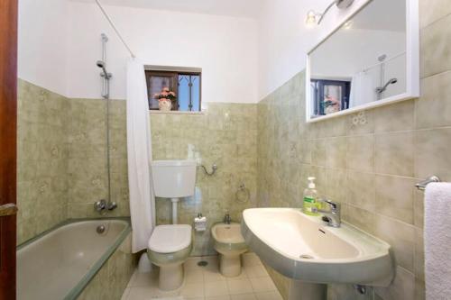 a bathroom with a sink and a toilet and a tub at Casa Silver, Gale - Sleeps 9 close to amenities and beach! in Guia