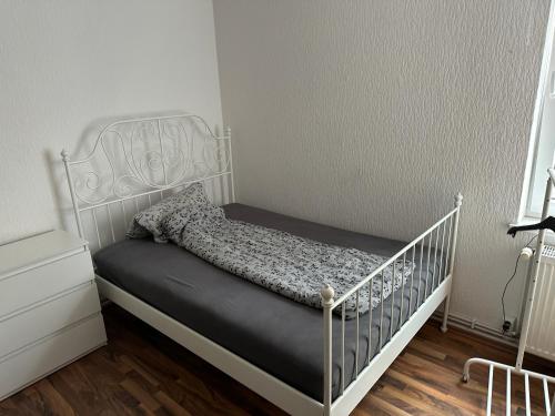 ein Bett mit einem weißen Kinderbett in einem Zimmer in der Unterkunft Apartment in Hannover