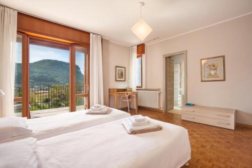 ガルダにあるCa' Le Terrazze With Poolのベッドルーム1室(ベッド2台、大きな窓付)