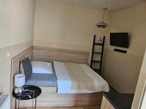 a small bedroom with a bed and a television at Hotel Taurus in Ostrava