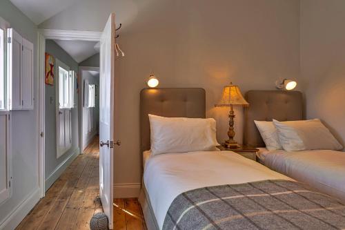 a bedroom with two beds and a lamp in it at Finest Retreats - Potters Cottage in Fowey