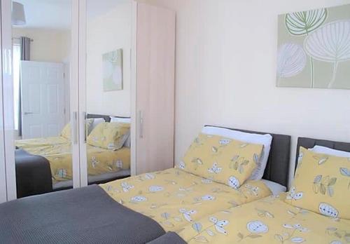 Un dormitorio con una cama con sábanas amarillas y un espejo. en Jubilee House - 4 bedroom central house - bright and spacious, 2 parking spaces, en Filey
