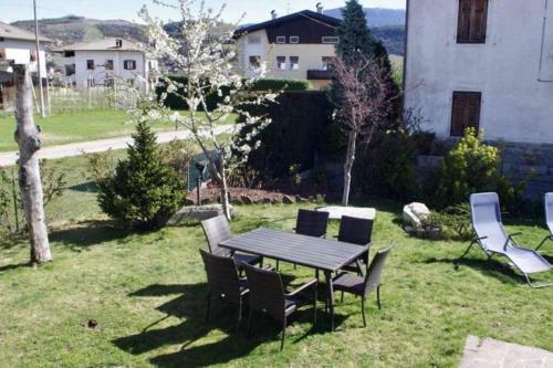 a picnic table and chairs in a yard at Casa del Tempo Elsa Tassullo Ospitar in Tassullo