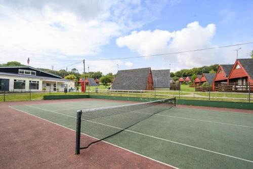 a tennis court with a net on top of it at COASTAL CHALET at Kingsdown Park with Pool & Tennis Court on-site No 64 in Kingsdown