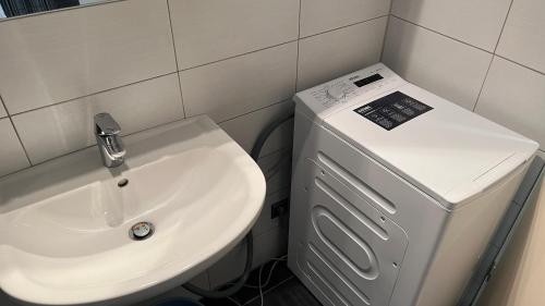 a bathroom with a sink and a washing machine at Apartment in Hannover! contactless check-in in Hannover