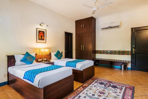 two beds in a hotel room with at Home@F37 Kailash Colony Metro in New Delhi