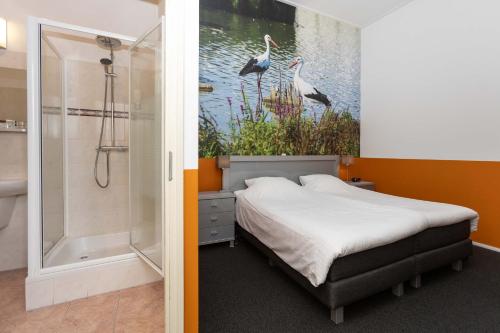 a bedroom with a bed and a shower with a painting of birds at Cosy Hotel in Historical Center of Blokzijl in Blokzijl
