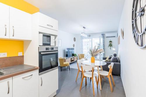 une cuisine et un salon avec une table et des chaises dans l'établissement Le Barcelone, Beau T2, Clim, Terrasse,Centre ville, à Montpellier