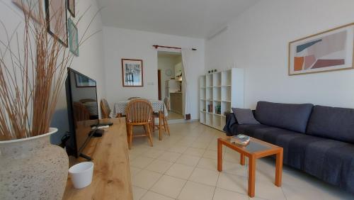 a living room with a blue couch and a table at Apartments TENA in Pula