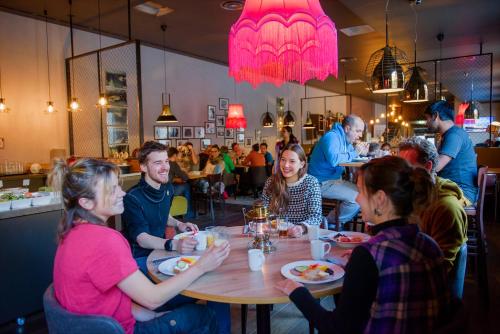 a group of people sitting around a table in a restaurant at Coal Miners’ Cabins in Longyearbyen