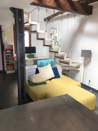 een slaapkamer met een geel bed en een trap bij Loft Adrimar in Santoña