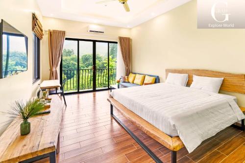 a bedroom with a bed and a balcony at Cerf Volant Soc Son Resort in Hanoi