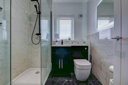 La salle de bains est pourvue d'un lavabo, de toilettes et d'une douche. dans l'établissement Ardfin Road - Prestwick The Open, à Prestwick