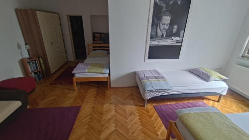 a living room with three beds and a mirror at Green Garden Group Accommodation in Osijek