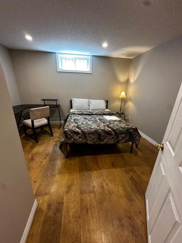 a bedroom with a bed and a chair and a window at Budget Stay in Kitchener- Near Town Centre- Food, Shopping, Transit in Kitchener