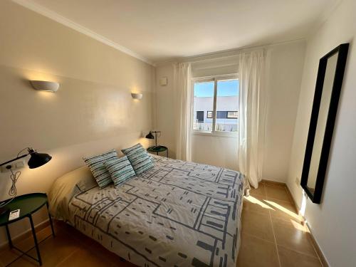 1 dormitorio con cama y ventana en Apartamento Jardines PG016, en Benitachell