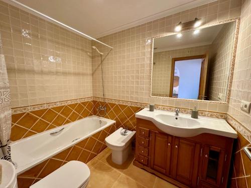 y baño con lavabo, bañera y aseo. en Apartamento Jardines PG016, en Benitachell