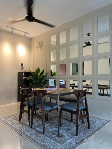 a dining room with a wooden table and chairs at Homestay Khan'Da Teluk Intan in Teluk Intan