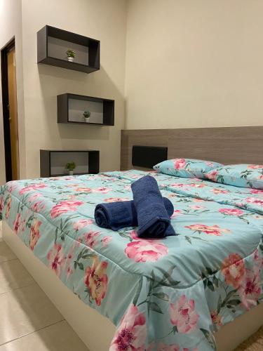 a bed with two blue towels on top of it at Homestay Khan'Da Teluk Intan in Teluk Intan