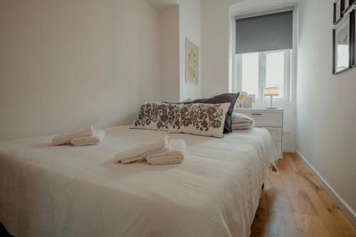 um quarto com uma cama branca e toalhas em Elegant Apartment 28 San Giacomo em Trieste